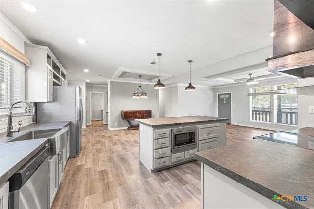 a kitchen with stainless steel appliances granite countertop a sink stove and refrigerator
