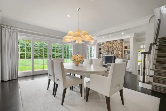 a dining room with furniture a chandelier and wooden floor