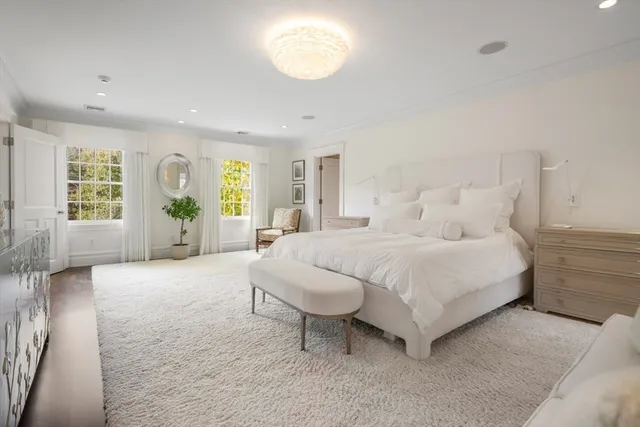 a spacious bedroom with a large bed and a chandelier