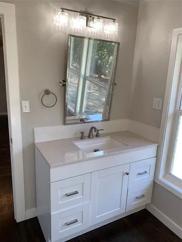 a bathroom with a granite countertop sink toilet and mirror