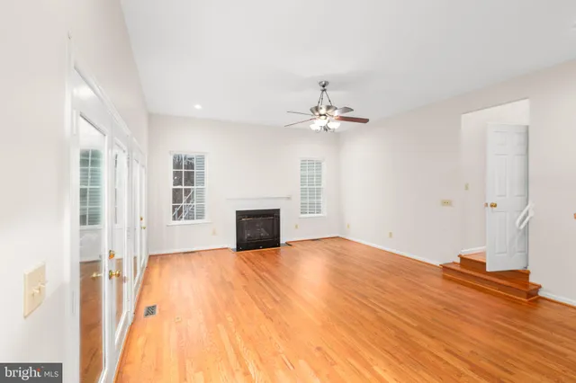an empty room with a window and a ceiling fan