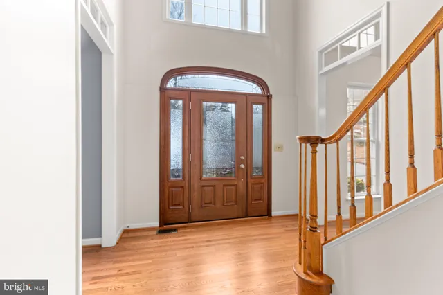 an empty room with wooden floor and fan