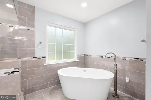 a view of an empty room with wooden floor and a ceiling fan