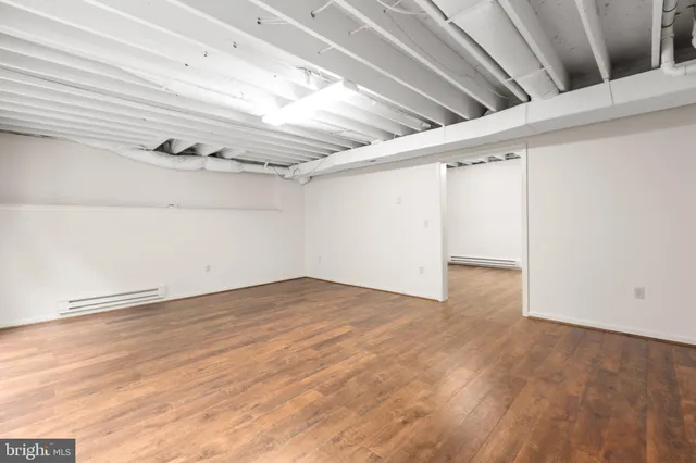 a view of a white house with a small yard and large tree