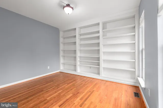 a view of a room with wooden floor and chandelier