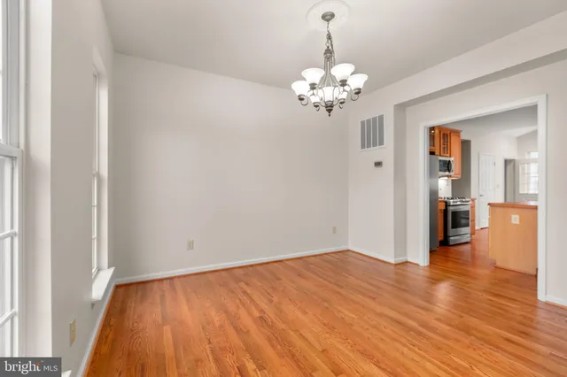 a view of a room with wooden floor and kitchen