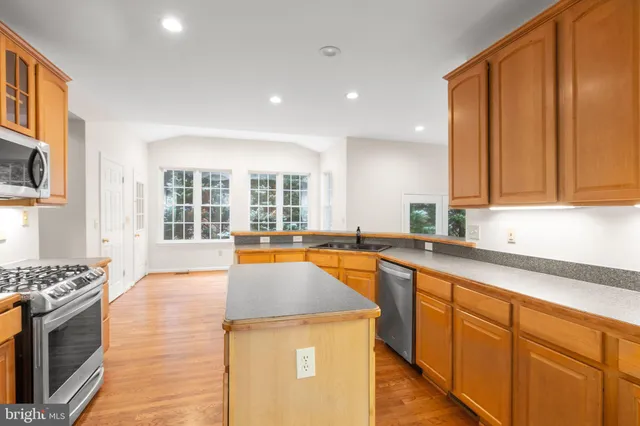 a kitchen with stainless steel appliances a refrigerator and a stove top oven