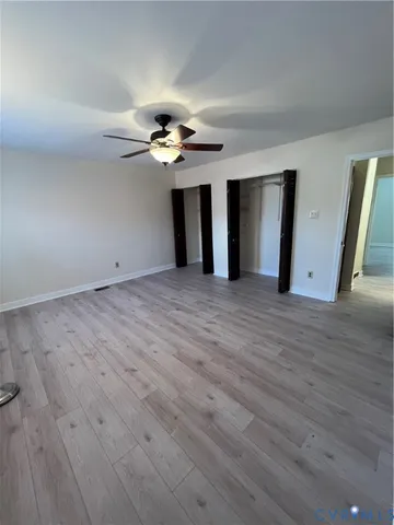 a view of an empty room with wooden floor