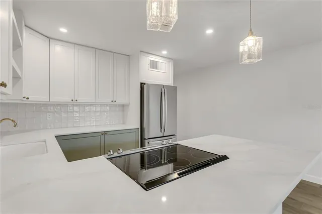 a kitchen with kitchen island a counter top space cabinets and stainless steel appliances