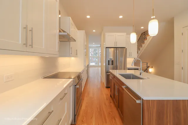 a kitchen with a sink a counter top space stainless steel appliances and cabinets