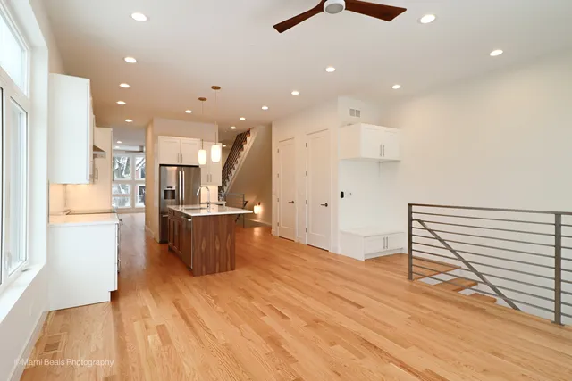 a view of kitchen with kitchen island stainless steel appliances refrigerator stove microwave and cabinets