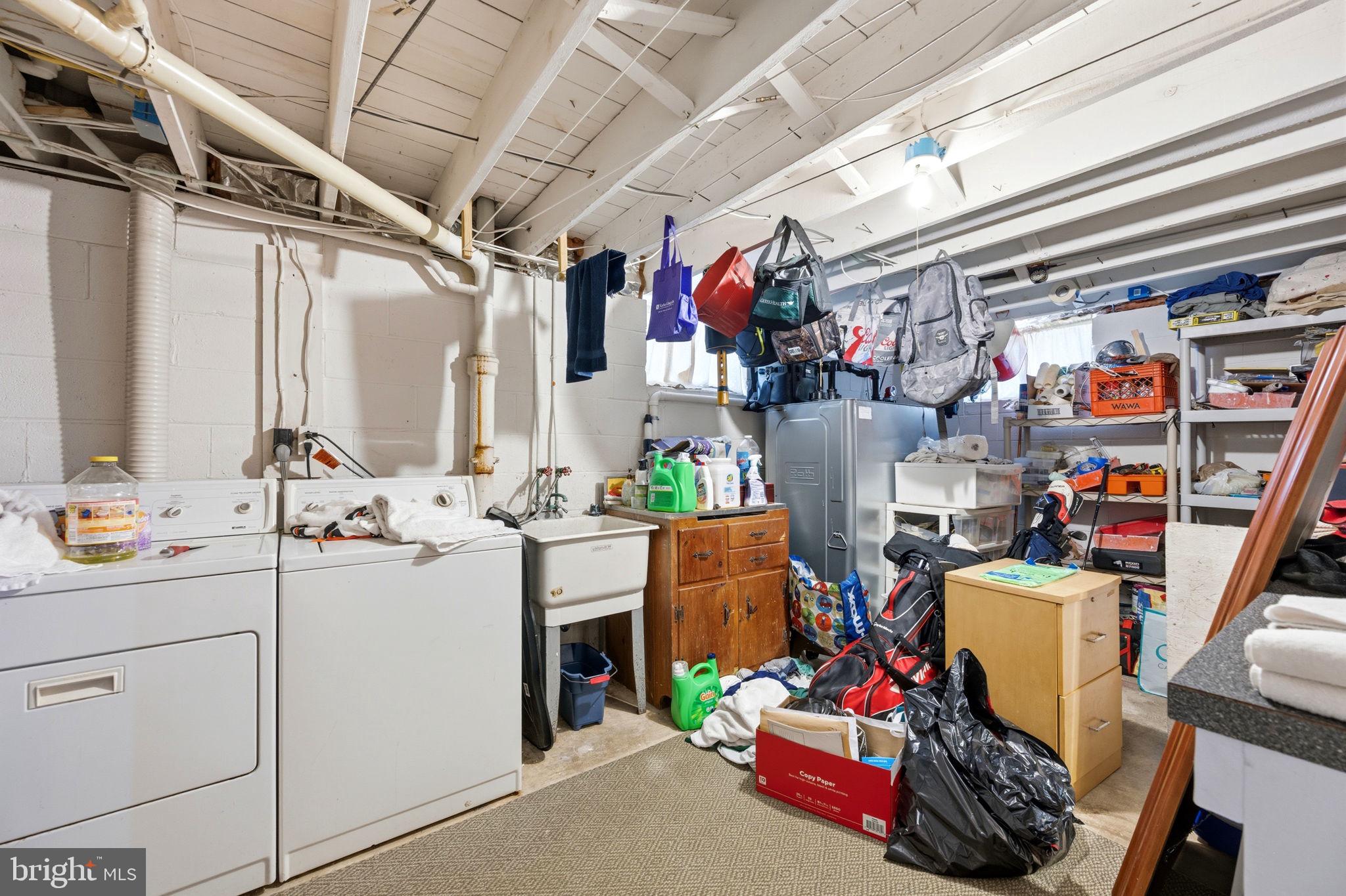 905 Amosland Road Morton, PA 19070 - Photo 39 of 44 Cluttered basement with laundry area.