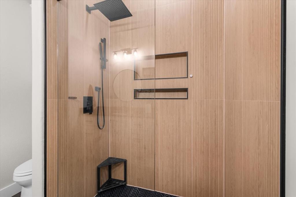 1059 Sweeney Way Weatherford, TX 76087 - Photo 21 of 37 Full bathroom featuring a walk-in shower with wood-look wall tiling, a rain shower head and handheld sprayer