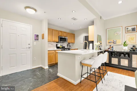 a kitchen with stainless steel appliances kitchen island granite countertop a refrigerator and cabinets