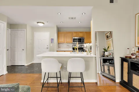 a kitchen with kitchen island granite countertop a sink cabinets and wooden floor