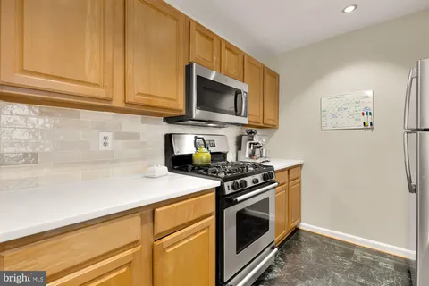 a kitchen with stainless steel appliances granite countertop a stove and a microwave