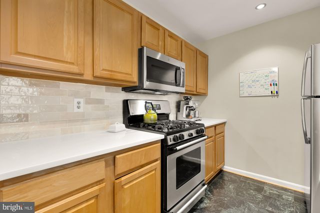 a kitchen with stainless steel appliances granite countertop a stove and a microwave