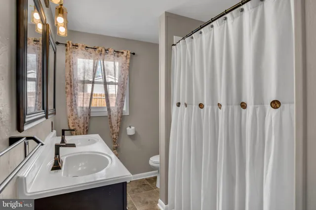 a living room with stainless steel appliances furniture and a kitchen view