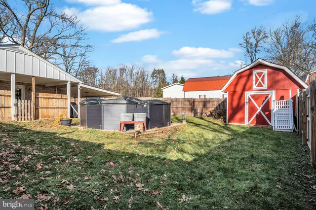 a view of a house with a yard covered with snow and trees