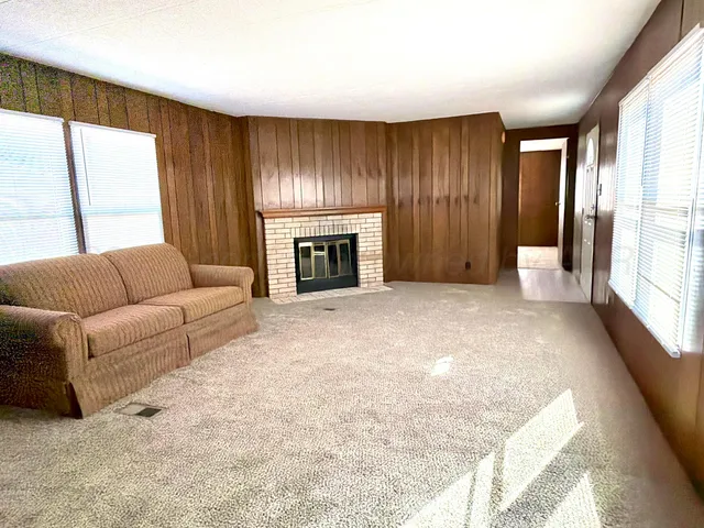 a large kitchen with a refrigerator and wooden floor