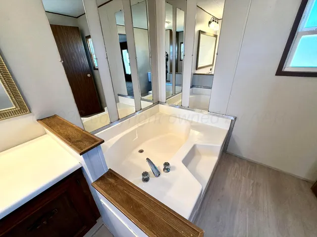 a bathroom with a granite countertop sink toilet and shower a mirror