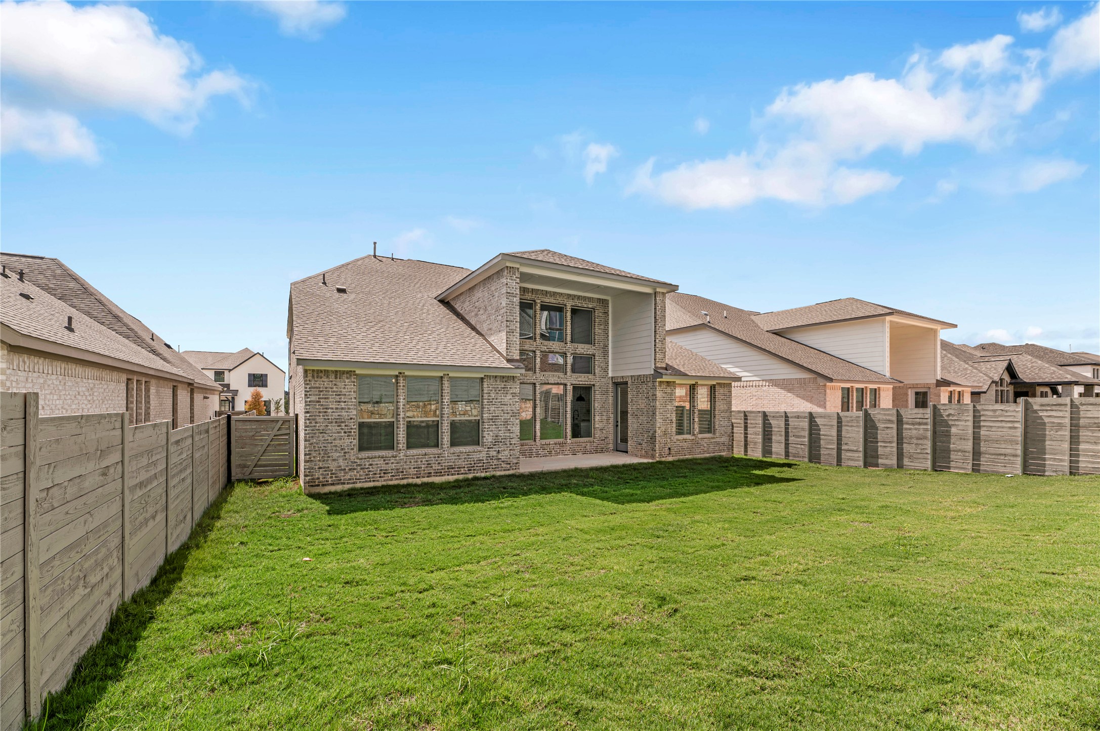 1508 Rodeo Ridge Drive Georgetown, TX 78628 - Photo 28 of 37 Back of house with a fenced backyard, roof with shingles, brick siding, and a patio area