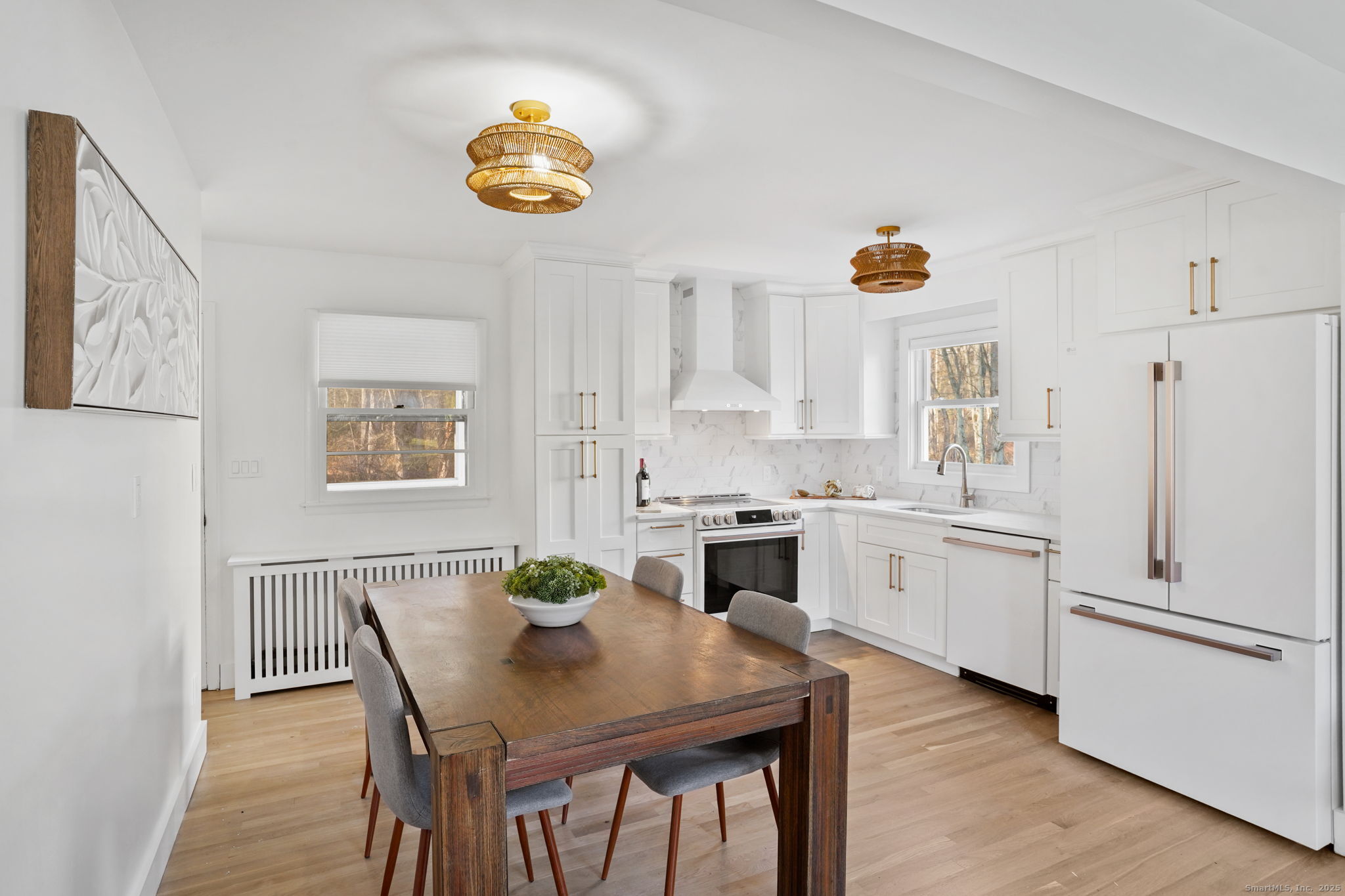 132 Toll House Lane Fairfield, CT 06825 - Photo 11 of 38 a kitchen with stainless steel appliances a dining table chairs and a refrigerator