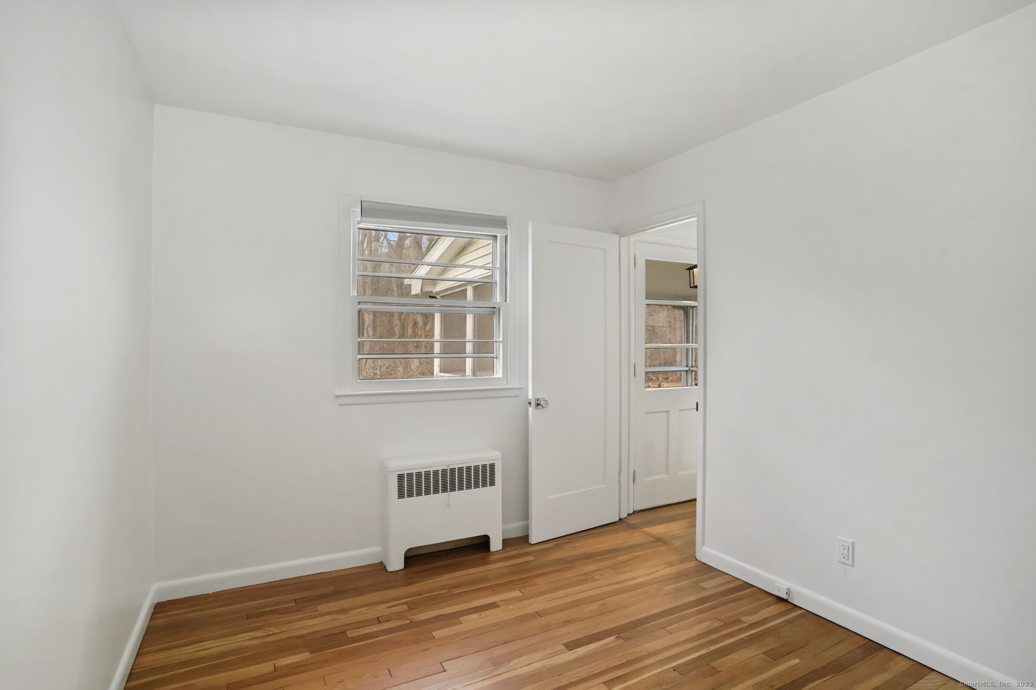 132 Toll House Lane Fairfield, CT 06825 - Photo 27 of 38 a view of an empty room with wooden floor and a window