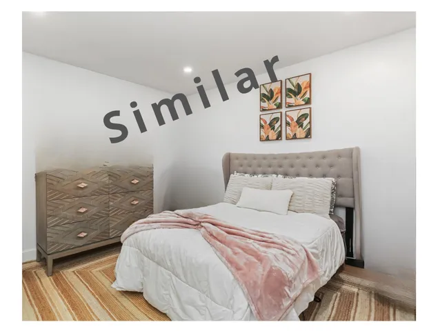 a bedroom with a bed and painting on the wall