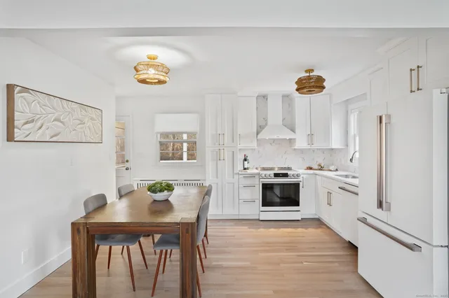 a kitchen with stainless steel appliances white cabinets and wooden floor