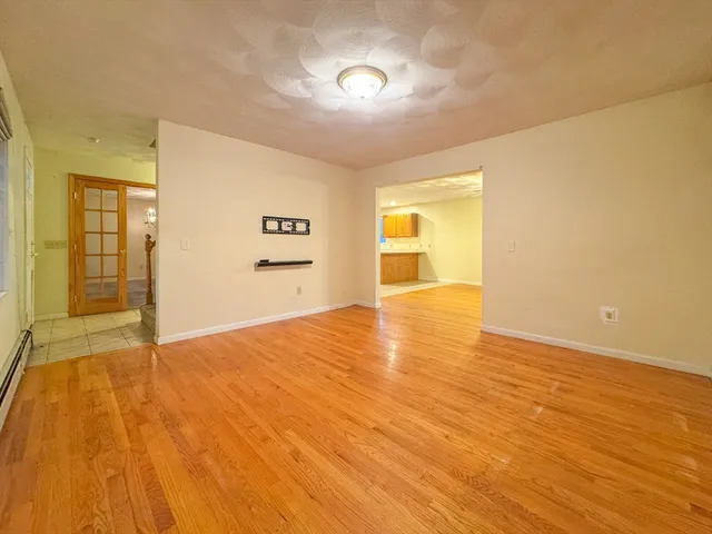 a view of an empty room with wooden floor