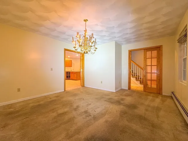 a view of a big room with windows and chandelier