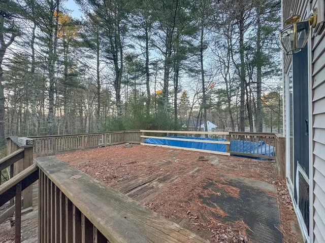 a view of roof deck with wooden fence and trees