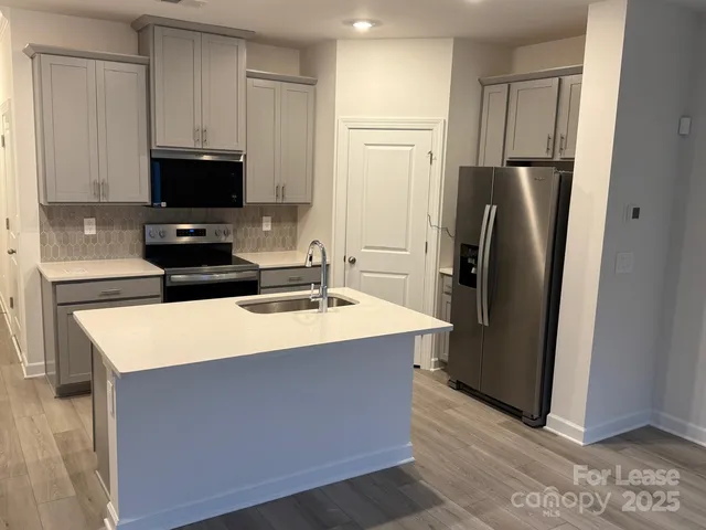 a kitchen with stainless steel appliances a refrigerator and a stove