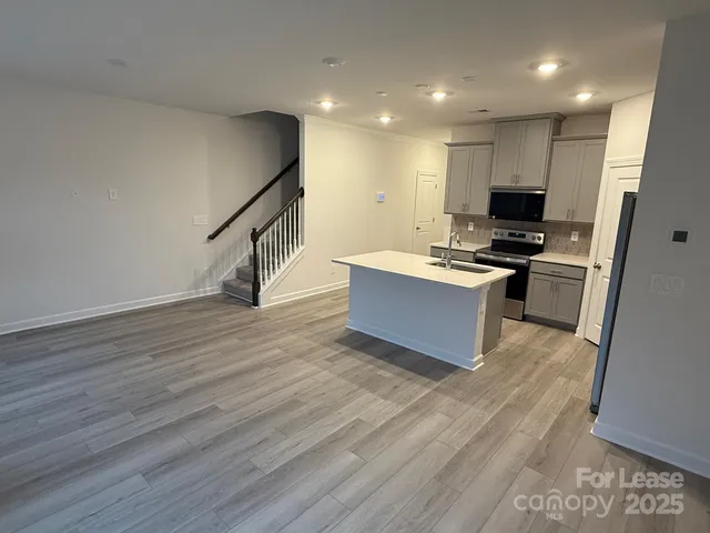 a view of kitchen with wooden floor and electronic appliances