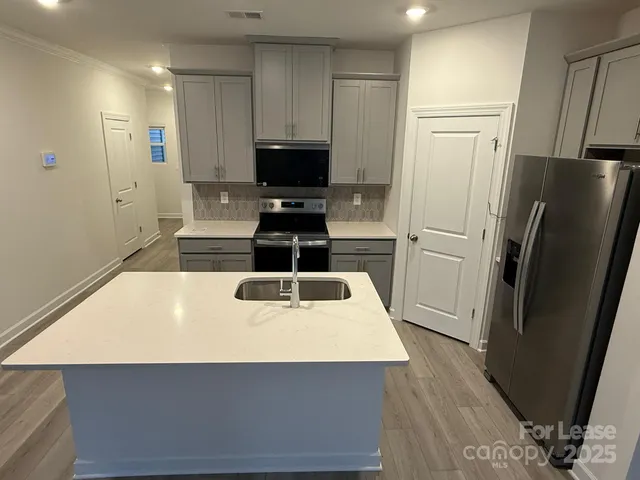 a kitchen with stainless steel appliances a refrigerator and a stove top oven