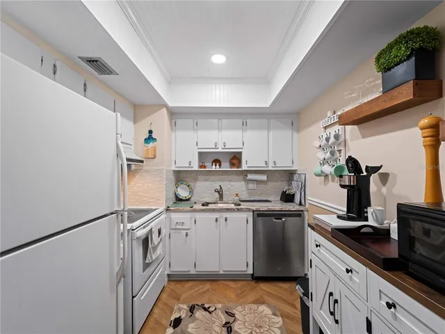 a kitchen with granite countertop cabinets stainless steel appliances and sink