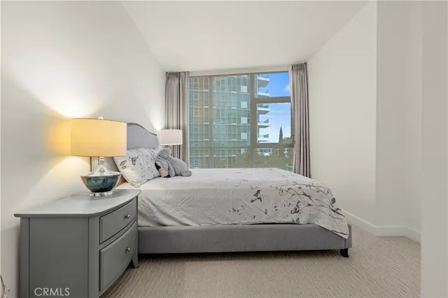 a bedroom with a bed and a lamp next to a window