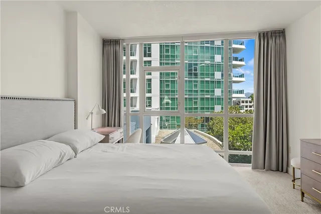 a bedroom with a bed and a large window