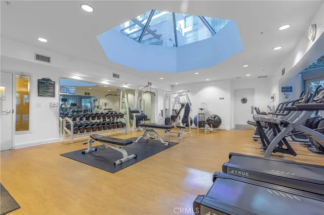 a room with gym equipment and kitchen view
