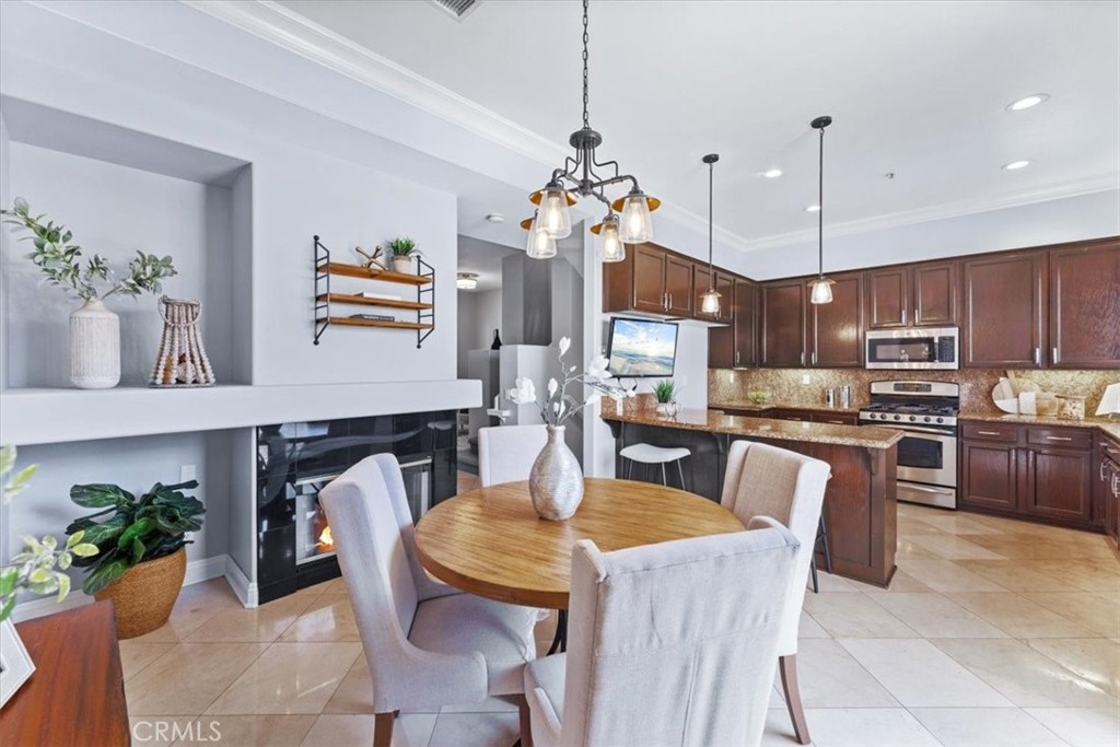 2950 Player Lane, Unit 4 Tustin, CA 92782 - Photo 1 of 1 a kitchen with kitchen island a counter top space appliances and a dining table