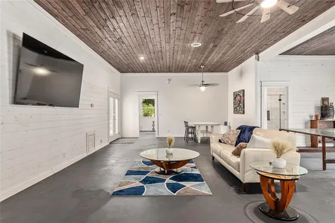 a view of a livingroom with wooden floor and a hallway