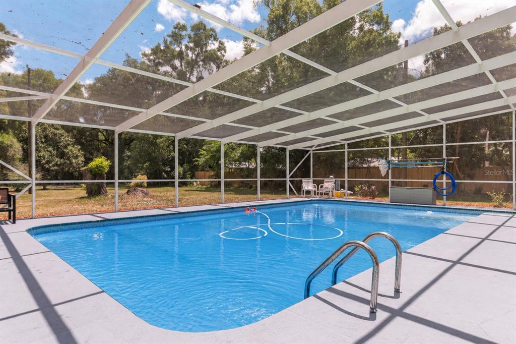 19451 Southeast 2 Street Williston, FL 32696 - Photo 43 of 99 a view of a swimming pool with wooden chairs in front of it
