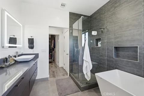 a bedroom with a bed dresser and a large window