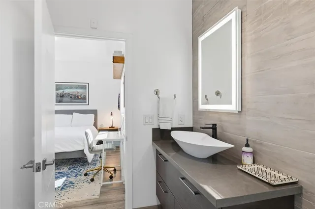 a spacious bedroom with a bed and a flat tv screen on dresser