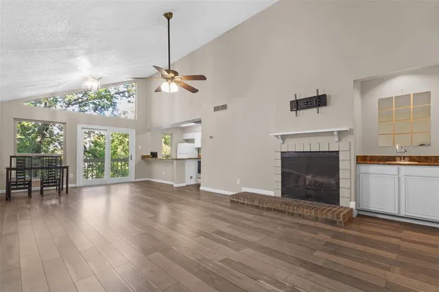 a view of empty room with wooden floor and fireplace