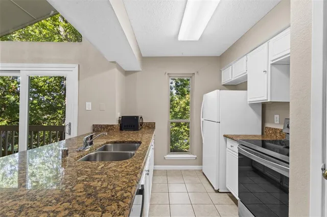 a kitchen with a stove a refrigerator and a sink