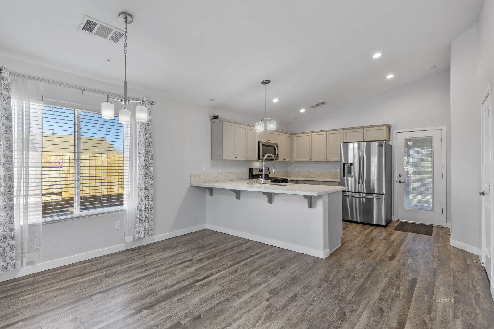 1200 South McCall Street Ridgecrest, CA 93555 - Photo 10 of 30 a kitchen with stainless steel appliances granite countertop a refrigerator a sink dishwasher a stove and white countertops with wooden floor