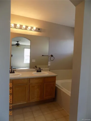 a bathroom with a tub sink and mirror