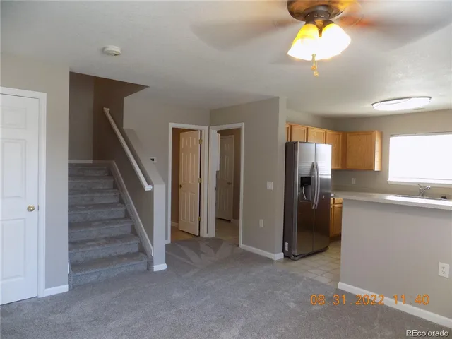 a view of a kitchen with a sink wooden cabinet and stainless steel appliances